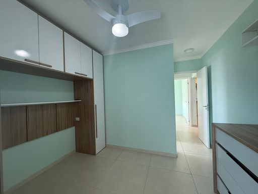 suíte com móveis planejados e ventilador de teto