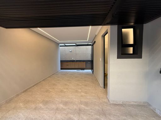 área gourmet externa retrátil com pia ampla e bancada em granito preta, com armários planejados e acesso a garagem com lavabo