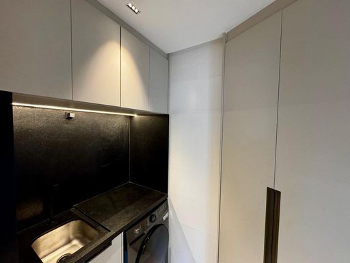 área de serviço com armários planejados e pia ampla em granito preta