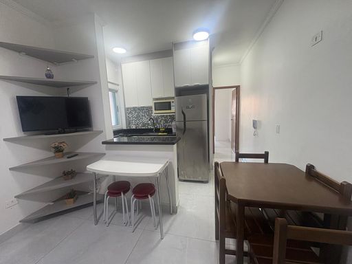 Sala semi integrada a cozinha com armários planejados e acesso a suíte