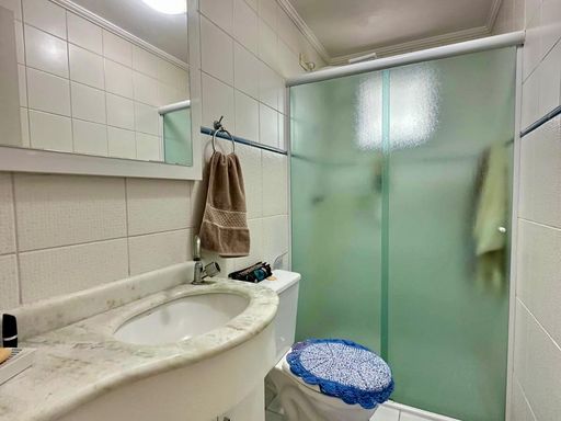 banheiro da suíte arejado com box de vidro