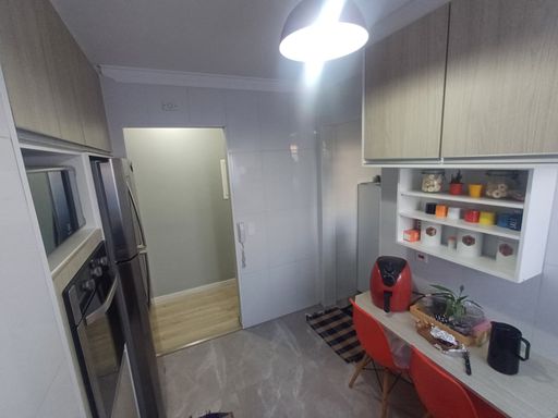 cozinha arejada com armários planejados e pia ampla em granito preta