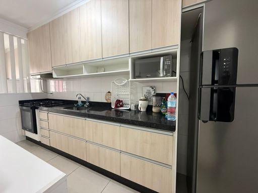 cozinha padrão americana com planejados, ampla pia em granito preta, semi integrada a área de serviço com acesso a varanda gourmet