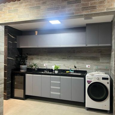 ampla pia em granito preto com churrasqueira e área de serviço, com armários planejados de primeiríssima qualidade