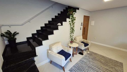 ampla sala 2 ambientes bem arejada com teto rebaixado, acesso a entrada principal e a escada para o piso superior em granito preta.