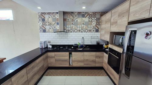 cozinha padrão americana com amplo balcão e pia em granito preto, com armários planejados de primeiríssima qualidade