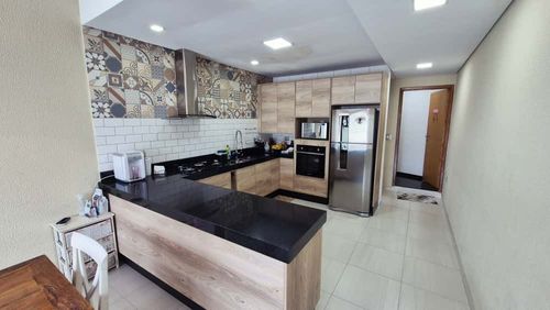 cozinha padrão americana com amplo balcão e pia em granito preto, com armários planejados de primeiríssima qualidade