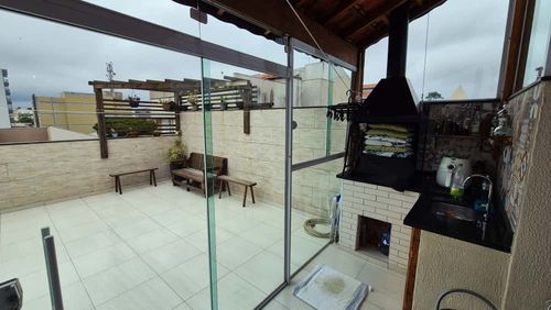 espaço gourmet no piso superior com churrasqueira a carvão e fechamento em vidro para total privacidade