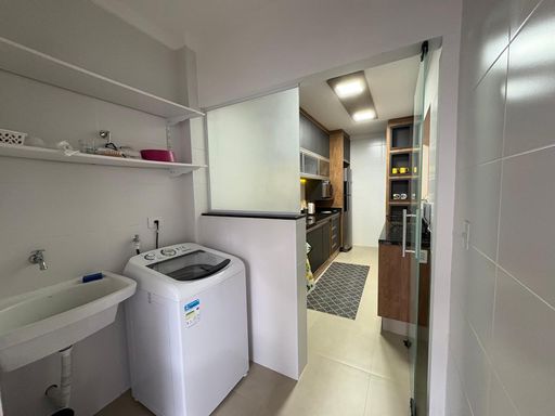 Área de serviço semi integrada a cozinha com porta de vidro e acesso a varanda gourmet