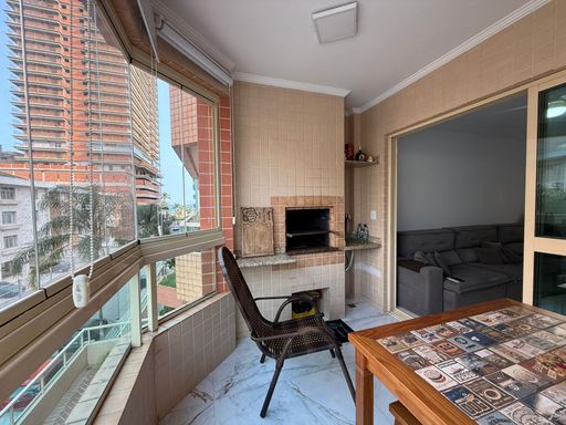 ampla varanda gourmet envidraçada com vista mar privilegiada, churrasqueira a carvão e cortina blackout