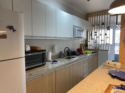 cozinha com armários planejados semi integrada a área de serviço, com acesso a varanda