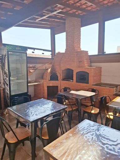 área gourmet envidraçada com churrasqueira a carvão e forno a lenha