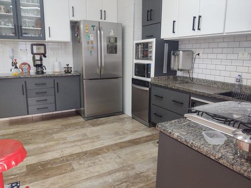 cozinha com armários planejados em total requinte, pedra em granito formato em L