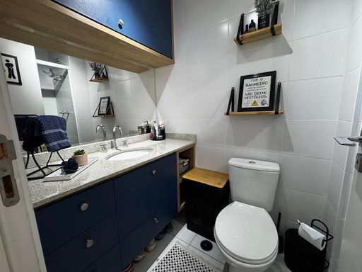 banheiro social com armários planejados impecável, amplo espelho e ampla pia em granito