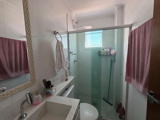 banheiro bem arejado com armário planejado e box de vidro