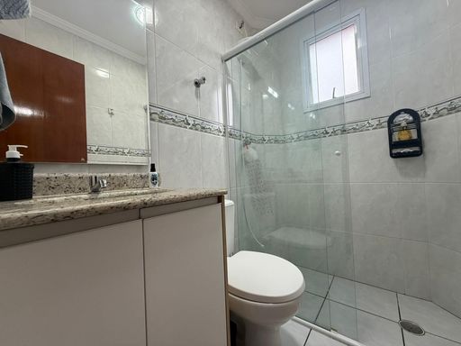 banheiro social arejado com box de vidro e armário planejado