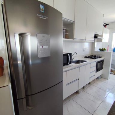 cozinha clean com armários planejados impecável semi integrada a área de serviço bem arejada