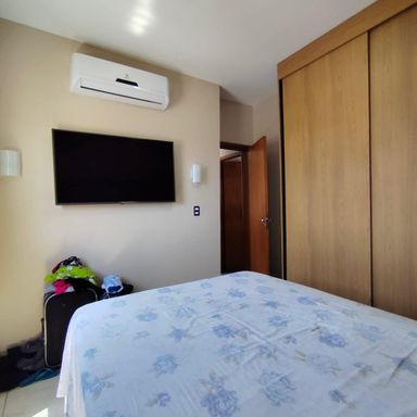 dormitório 1 com armário planejado, ar condicionado e vista livre