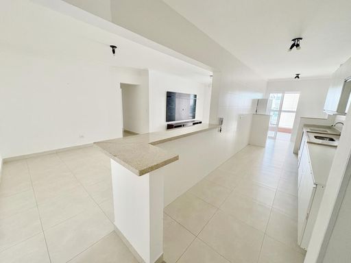 cozinha padrão americana, semi integrada a área de serviço e a sala dois ambientes