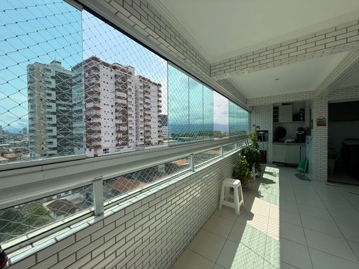 ampla varanda gourmet envidraçada com churrasqueira a carvão, tela de proteção e vista livre