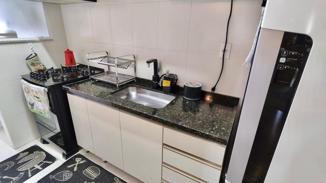 Cozinha semi integrada a área de serviço com divisória de vidro
