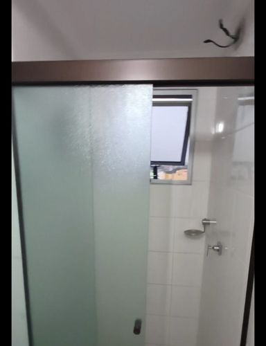 banheiro com armário planejado e box de vidro bem arejado