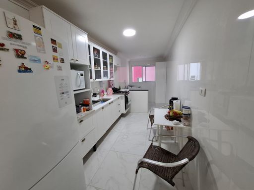 cozinha clean com armários planejados e acesso a área de serviço bem arejada
