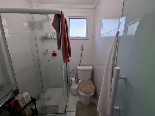 banheiro da suíte clean com box de vidro, bem arejado