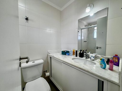 banheiro da suíte 2 com armário planejado, ampla pia e box blindex bem arejado