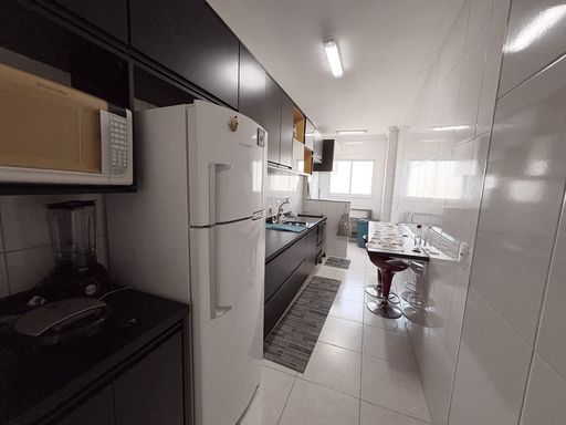 cozinha com armários planejados semi integrada a área de serviço bem arejada e iluminada