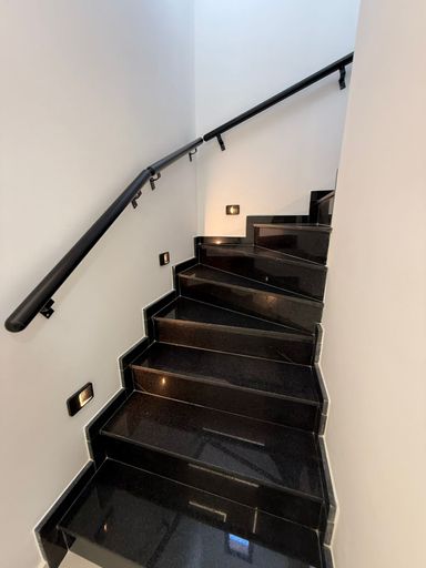 escada de acesso ao terceiro piso em granito preto