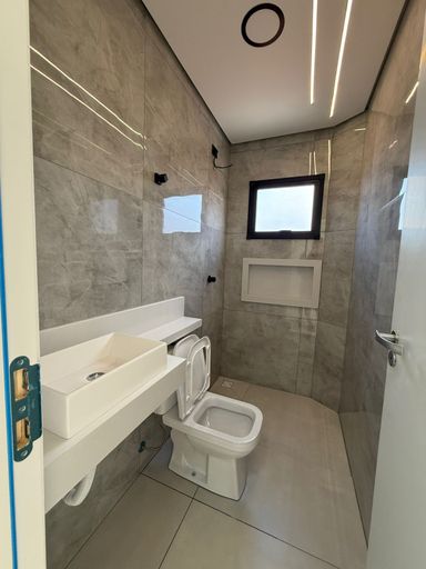 banheiro da suíte bem arejado com nicho e sistema de iluminação em LED com teto rebaixado