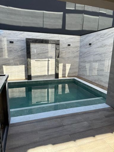 piscina com cascata e fino acabamento semi integrada a área gourmet