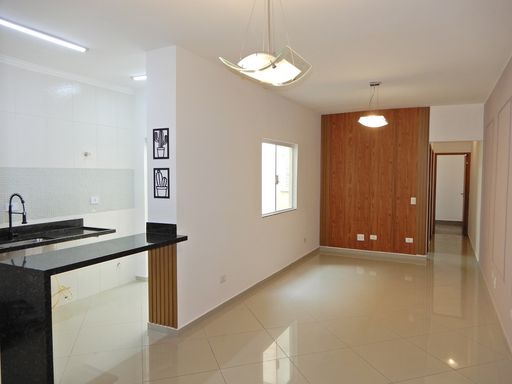 Sala ampla 2 ambientes com painel em madeira, semi integrada a cozinha padrão americana