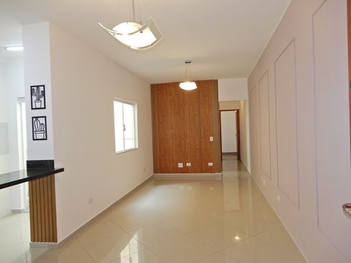 Sala ampla 2 ambientes com painel em madeira, semi integrada a cozinha padrão americana