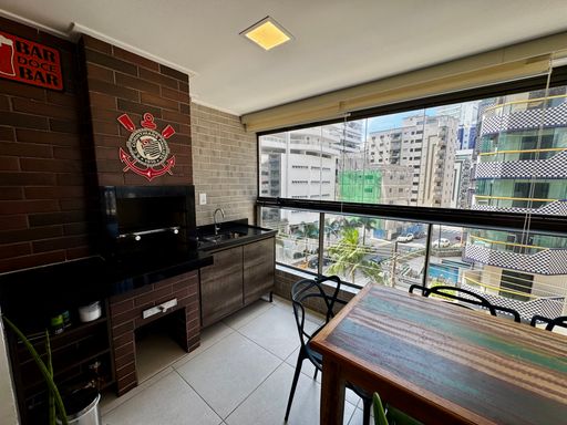 ampla varanda gourmet envidraçada com vista mar privilegiada, churrasqueira a carvão e cortina blackout