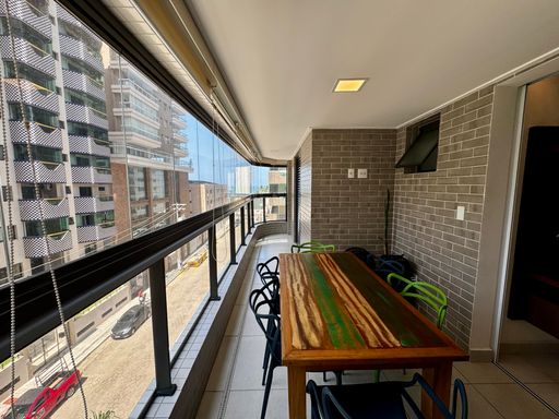 ampla varanda gourmet envidraçada com vista mar privilegiada, churrasqueira a carvão e cortina blackout