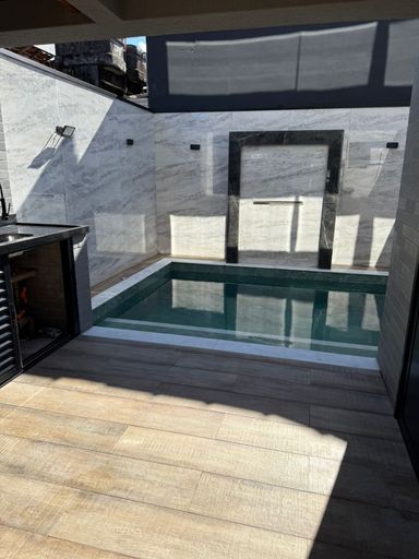 piscina com cascata e fino acabamento semi integrada a área gourmet