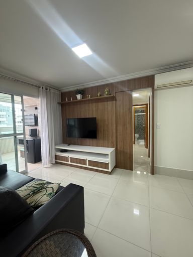 ampla sala 2 ambientes com acesso a varanda gourmet envidraçada, ar condicionado e porta de correr em madeira de acesso aos dormitórios.