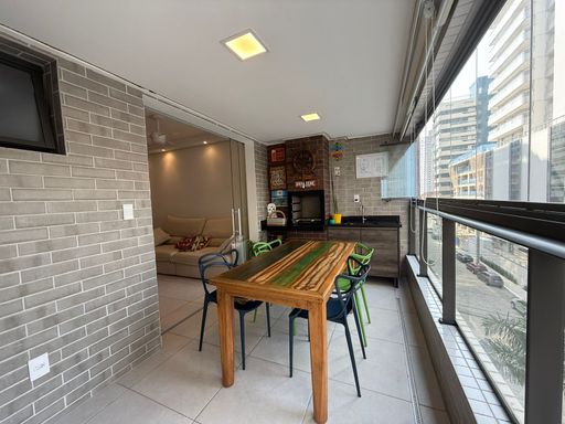 ampla varanda gourmet envidraçada com vista mar privilegiada, churrasqueira a carvão e cortina blackout