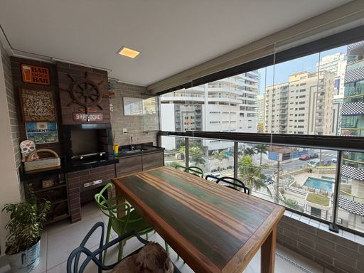 ampla varanda gourmet envidraçada com vista mar privilegiada, churrasqueira a carvão e cortina blackout