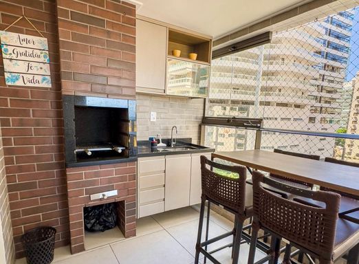 ampla varanda gourmet com vista mar, envidraçada e com tela de proteção, churrasqueira a carvão e armário planejado