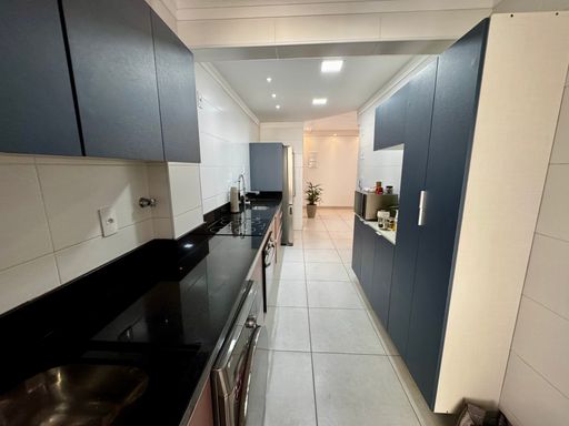 cozinha com móveis planejados semi integrada a área de serviço