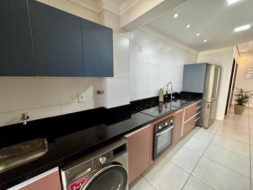 cozinha com móveis planejados semi integrada a área de serviço