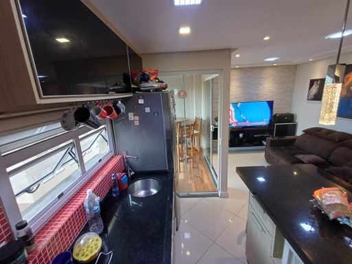 cozinha com armários planejados e ilha com acesso a sacada envidraçada