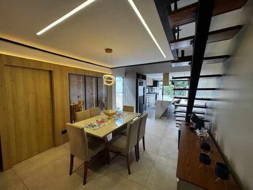 sala de jantar na cobertura com cristaleira impecável com sistema de iluminação em Led e acesso privado na mobília para a área de serviço