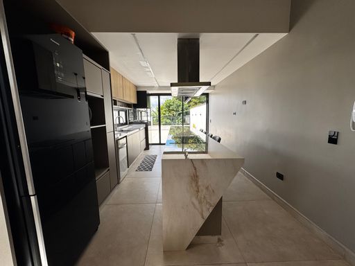 cozinha gourmet impecável com acesso a área externa com porta de correr de vidro