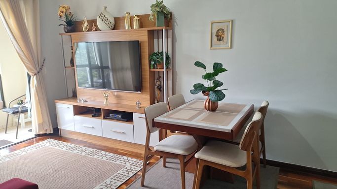 sala ampla integrada a sacada envidraçada com vista privilegiada a rua principal
