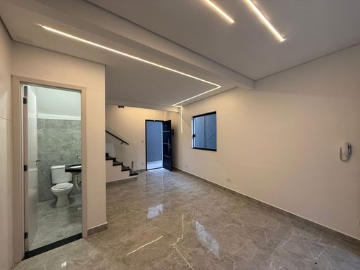 sala com acesso a entrada principal e ao lavabo com fino acabamento em porcelanato e sistema de iluminação em LED
