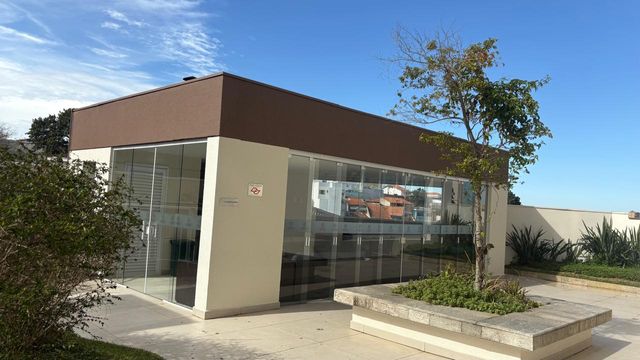 área externa do espaço gourmet envidraçado com churrasqueira a carvão e forno de pizza